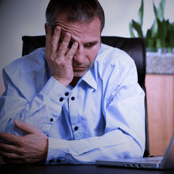 Overwhelmed business owner holding his head in frustration due to complex marketing.