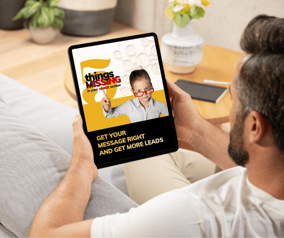 A man sits on the sofa while reading the "5 Things Missing In Your About Section" ebook on his tablet.